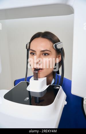 Affascinante signora è sottoposta a procedure di scansione 3D su apparecchiature moderne Foto Stock