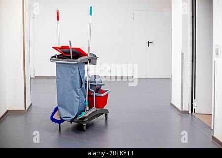 Carrello per pulizia classico. Scopa, secchio, detergenti, prodotti per la pulizia in luoghi pubblici, hotel, supermercati, aeroporti, servizi igienici. interno con verde Foto Stock