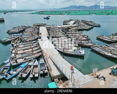 YANTAI, CINA - 28 LUGLIO 2023 - le barche da pesca impegnate nell'agricoltura offshore tornano al porto per ripararsi dal vento al porto di pesca di Dongkou Foto Stock