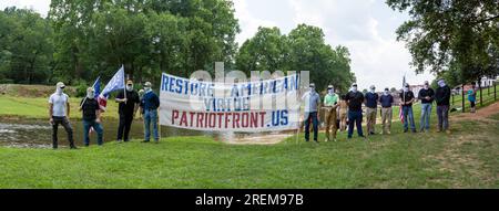 Prattville, Alabama, USA - 24 giugno 2023: Membri del Patriot Front, un gruppo di odio nazionalista bianco, neo-fascista, si coprono il volto tenendo in mano una banne Foto Stock