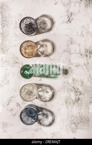 Alcuni vetri di cristallo colorati fanno ombra su una superficie ruvida bianca e grigia Foto Stock