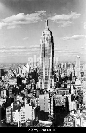 New York, New York: c. 1950 l'edificio più alto del mondo continua a torreggiare sullo skyline di New York. L'Empire State Building si erge per 1250 metri con 102 piani. Foto Stock