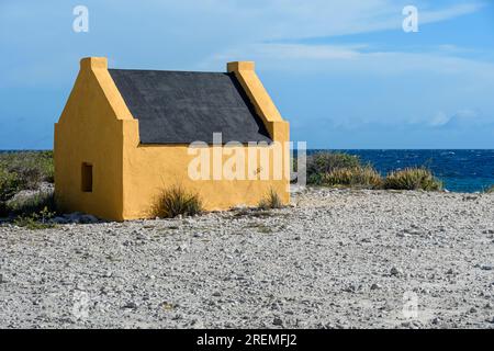 Ochre Yellow slave Huts a Red Pan, sud di Bonaire. Queste capanne furono costruite nel 1850 durante il periodo della schiavitù. Foto Stock