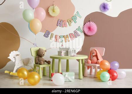 Interno per la festa di compleanno dei bambini con palloncini, giocattoli e mobili Foto Stock