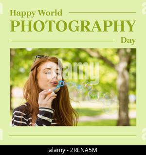 Happy World Photography Day testo su verde con la donna caucasica felice che soffia bolle nel parco Foto Stock