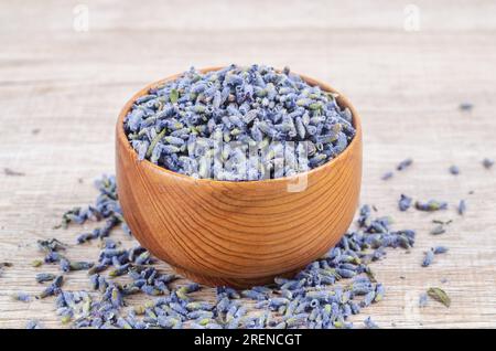 Cime di lavanda essiccate in una tazza di legno per la medicina alle erbe o il tè. Foto Stock