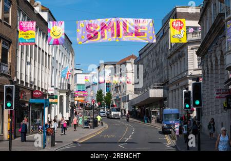Colorato striscione sorriso appeso su North Street nel centro di Brighton, in estate, nella città di Brighton & Hove, East Sussex, Inghilterra, Regno Unito. Foto Stock