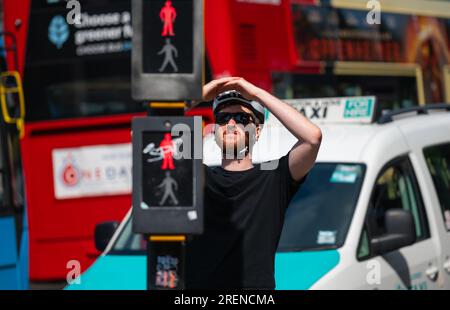 Ciclista in bicicletta, si è fermato ai semafori rossi, rispettando il codice dell'autostrada e le regole della strada in una città trafficata dell'Inghilterra, Regno Unito. Foto Stock