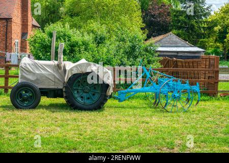 trattore con copertura e aratro parcheggiato di fronte all'azienda agricola in sud africa Foto Stock