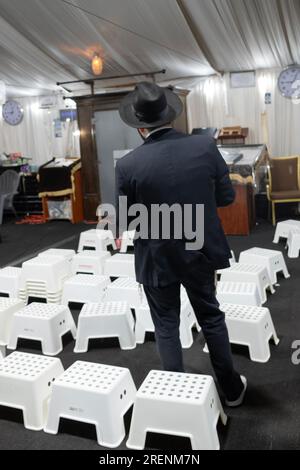 Su Tisha B'Av un uomo prega da solo circondato da posti molto bassi commisurati allo spirito lutto di questo triste giorno. Nella contea di Rockland, New York. Foto Stock