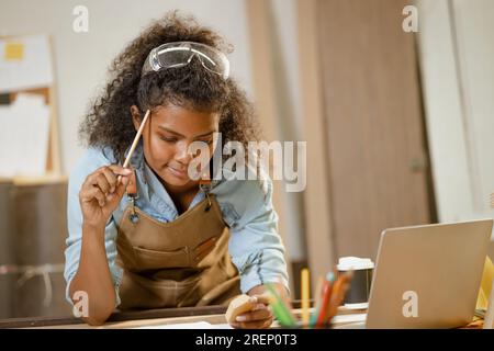 Falegname donna intelligente falegname mobili per la casa in legno disegno schizzo creativo nuovo prodotto in officina di legno. Foto Stock