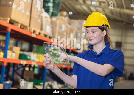 lavoratori moderni che utilizzano un tablet digitale con software di gestione dell'inventario logistico per controllare il carico monitorare le merci in magazzino Foto Stock