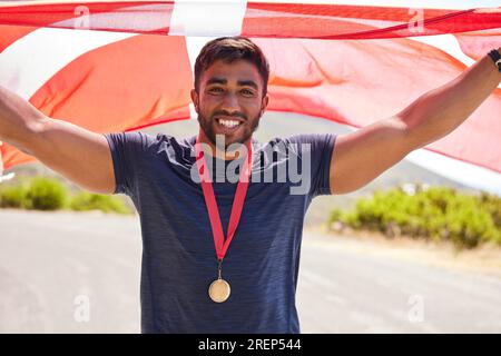 Ritratto, bandiera e uomo con medaglia per vincitore, concorso sportivo o vincitore in strada. Felice, Danimarca e un atleta professionista con Foto Stock