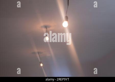 Soffitto bianco in cemento con lampadine luminose Foto Stock