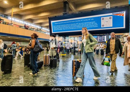 Londra, Regno Unito. 29 luglio 2023. In attesa di informazioni sui grandi schermi - i treni continuano a circolare con un servizio ridotto e le persone continuano ad arrivare nella speranza di ottenerne uno. L'ultimo sciopero ferroviario sulla retribuzione e le condizioni alla stazione di Euston. Crediti: Guy Bell/Alamy Live News Foto Stock