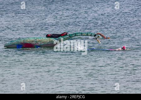 Swanage, Dorset, Regno Unito. 29 luglio 2023. Percy Searonster il modello di dinosauro plesiosauro realizzato con 600 bottiglie di plastica del peso di 60-65kg creato dalle sculture di Glenn Martin viene trainato lungo Swanage Bay dal nuotatore Oly Rush e da altri nuotatori. Una nuotata di 12 ore per Oly, parte del suo intenso programma di allenamento per il suo tentativo di record mondiale, 30 ore di nuoto intorno alla splendida isola di Itaca, in Grecia, a settembre. Con l'obiettivo di aumentare la consapevolezza circa gli impatti devastanti dell'inquinamento plastico, nonché i fondi per il progetto Planet Earth e Healthy Seas. Crediti: Carolyn Jenkins/Alamy Live News Foto Stock