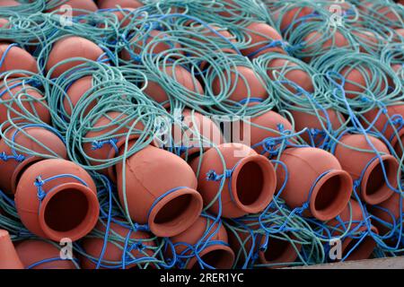 Trappole in pentola di polpo in terracotta in reti. Industria della pesca di argilla in Spagna Foto Stock