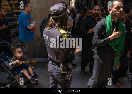 Barcellona, Spagna. 29 luglio 2023. Un agente di polizia è in guardia durante la celebrazione della festa religiosa di Ashura. La comunità sciita di Barcellona celebra Ashura per le strade di Ciutat Vella. Ashura è un importante giorno islamico che cade il decimo giorno del mese di Muharram, il primo mese del calendario lunare islamico. (Foto di Paco Freire/SOPA Images/Sipa USA) credito: SIPA USA/Alamy Live News Foto Stock