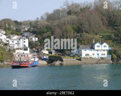 Fowey, Cornovaglia, Regno Unito, marzo 2022: Il traghetto Fowey raggiunge Bodinnick. Old Ferry Inn e Ferryside, un'ex casa di Daphne Du Maurier, entrambi visibili. Foto Stock