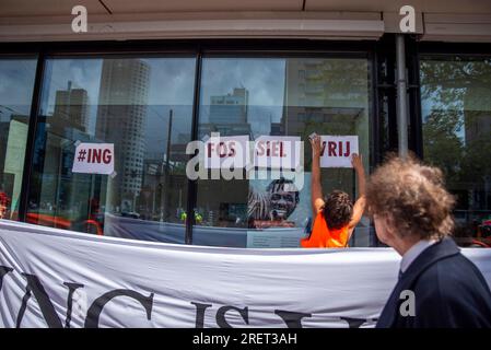 Rotterdam, Olanda meridionale, Paesi Bassi. 29 luglio 2023. Un attivista del clima appende dei segnali durante una manifestazione contro ING Bank. Il 29 luglio 2023, come parte della campagna ''ING Hot Summer Tour'', gli attivisti della ribellione di estinzione manifestano in una filiale della ING Bank a Rotterdam, nei Paesi Bassi. (Immagine di credito: © James Petermeier/ZUMA Press Wire) SOLO USO EDITORIALE! Non per USO commerciale! Foto Stock