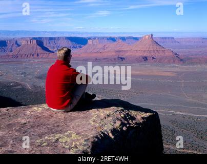 Vista dal Porcupine Rim alla Castle Valley con Castleton Tower, escursionista, escursionista, visitatore, seduto, Colorado Riverway, Utah, USA Foto Stock