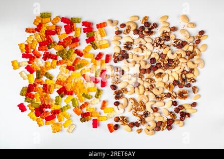 Confronto tra malsano e sano, orsi gommosi e varie noci, su bianco Foto Stock