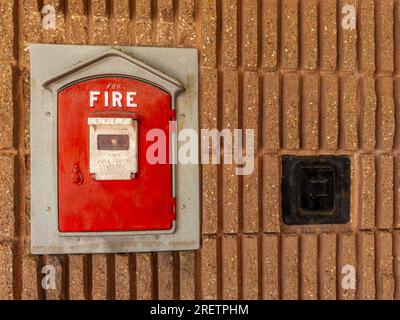 Cassetta rossa per allarme antincendio d'epoca montata sul lato di un edificio municipale in città. contesto. Primo piano. Foto Stock