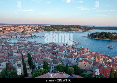 Vista al tramonto sulle isole del Mediterraneo, le barche e i tetti delle case nell'antica città istriana di Rovigno, Croazia Foto Stock