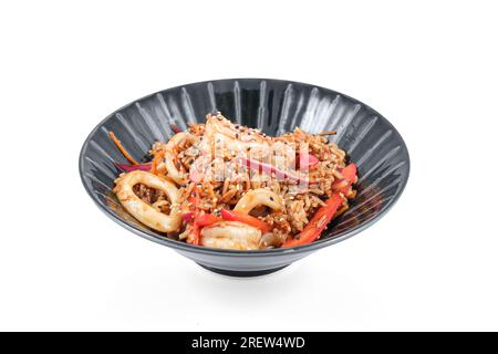 Ciotola con delizioso riso fritto con verdure assortite e calamari conditi con semi di sesamo Foto Stock