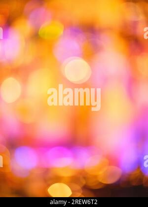 Sfondo astratto sfocato con luci colorate luminose e un effetto bokeh rotondo multicolore che brilla in una stanza luminosa con una luce brillante Foto Stock