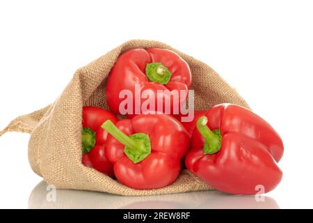 Diversi peperoni rossi in un sacco di iuta, macro, isolati su sfondo bianco. Foto Stock