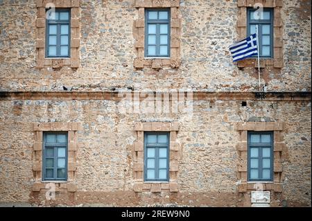Un vecchio edificio in pietra con una bandiera greca, Piazza Syntagma, Nafplio Foto Stock