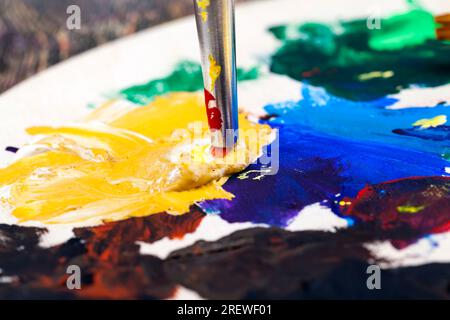 olio e altre vernici con pennelli per la creatività, il processo creativo di disegno mescolando diversi colori di vernici con pennelli artistici, pennelli artistici a. Foto Stock