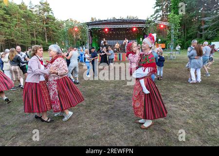 La gente del posto vestita con abiti tradizionali kihnu che festeggiano e ballano sulla jaanipaeva, a metà estate sull'isola di kihnu, sul mar baltico, in estonia Foto Stock