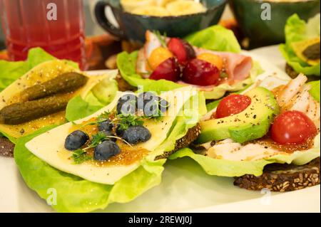 Panini sani e colorati con insalata, frutti di bosco, marmellata, formaggio e affettati Foto Stock