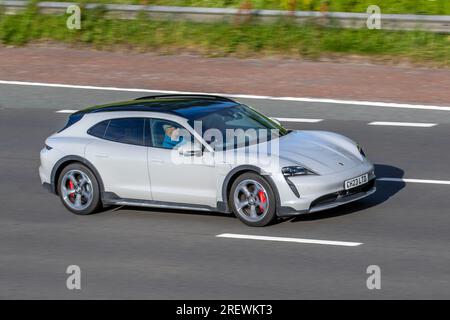 2023 White Grey Porsche Taycan 4S Cross Turismo 571 CV Performance Overboost 93 kWh, Estate Electricity Power 360 kW ; viaggia a velocità sostenuta sull'autostrada M6 a Greater Manchester, Regno Unito Foto Stock