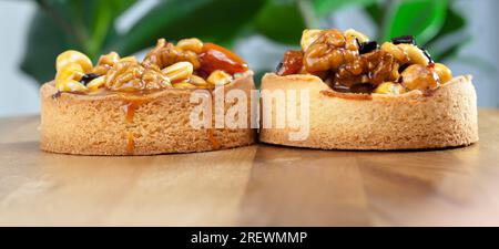 croccante croccante con ripieno, in tartartine di impasto di noci e frutta secca ricoperta di caramello, una piccola analogia di una torta con una varietà di ripieno Foto Stock