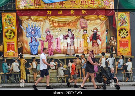 Una famiglia caucasica passa davanti a un murale dell'artista singaporiano Yip Yew Chong che ritrae un'opera cantonese; Temple St., Chinatown, Singapore Foto Stock