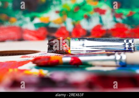 olio e altre vernici con pennelli per la creatività, il processo creativo di disegno mescolando diversi colori di vernici con pennelli artistici, pennelli artistici a. Foto Stock