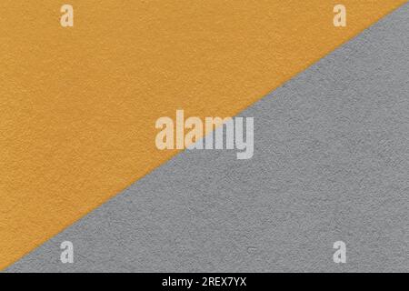 Consistenza di sfondo di carta arancio scuro e grigio artigianale, metà due colori, macro. Struttura in cartone grigio kraft vintage. Sfondo astratto clos Foto Stock