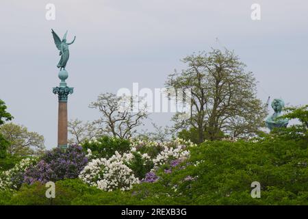 Colonna Ivar Huitfeldt e statua della principessa Maria dietro gli alberi di lilla nel parco Langelinie di Copenaghen, Danimarca Foto Stock