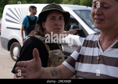 Stepnohirsk, Ucraina. 5 luglio 2023. Svitlana Ganza (51), capo della comunità del villaggio di Kamyanske, riceve aiuti umanitari da volontari. Si dice che l'Ucraina abbia due eserciti - l'esercito e i volontari. Questa serie di foto documenta il lavoro congiunto di volontari ucraini e polacchi nella distribuzione di aiuti umanitari ai villaggi in prima linea nella regione di Zaporizhia: Primorsky e Stepnohirsk. Cibo, forniture per la pulizia, acqua potabile e un generatore di elettricità sono stati donati alle autorità locali. Credito: SOPA Images Limited/Alamy Live News Foto Stock