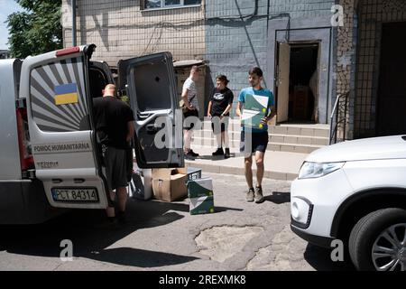 Zaporizhzia, Ucraina. 5 luglio 2023. Volontari che caricano furgone per diffamazione umanitaria nei villaggi vicini al fronte. Si dice che l'Ucraina abbia due eserciti - l'esercito e i volontari. Questa serie di foto documenta il lavoro congiunto di volontari ucraini e polacchi nella distribuzione di aiuti umanitari ai villaggi in prima linea nella regione di Zaporizhia: Primorsky e Stepnohirsk. Cibo, forniture per la pulizia, acqua potabile e un generatore di elettricità sono stati donati alle autorità locali. Credito: SOPA Images Limited/Alamy Live News Foto Stock