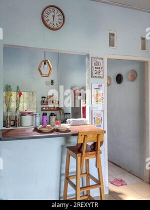 La cucina ha un tavolo da pranzo bar in legno che si collega al soggiorno Foto Stock