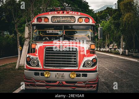 Antigua, Guatemala - 22 maggio 2023: Strada vuota ad Antigua con strada acciottolata e autobus parcheggiati per il pollo Foto Stock