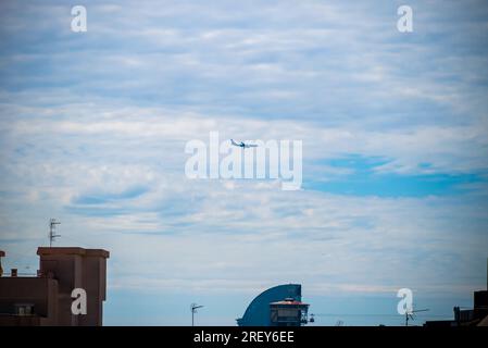 Barcellona, Spagna - maggio 26 2022: L'aereo vola sopra i tetti in direzione dell'aeroporto internazionale di Barcellona. Foto Stock