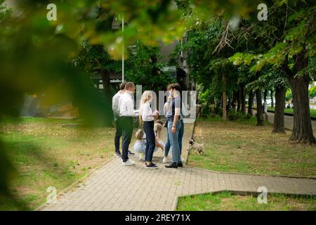 Gruppo di adolescenti delle superiori che stanno fuori, a parlare e ridere, a scuola, all'università, sei Foto Stock