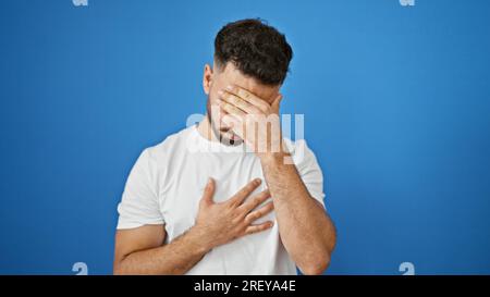 Giovane arabo malato tossisce su sfondo blu isolato Foto Stock