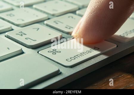 Bangkok, Thailandia - 30 luglio 2023: Utente del computer che preme il tasto comando sulla tastiera Mac di Apple. Foto Stock
