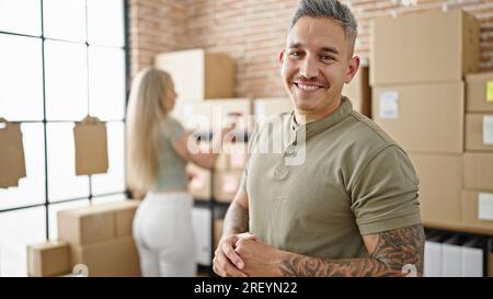Uomini e donne che lavorano nel settore dell'e-commerce che scansionano i pacchi sorridendo in ufficio Foto Stock